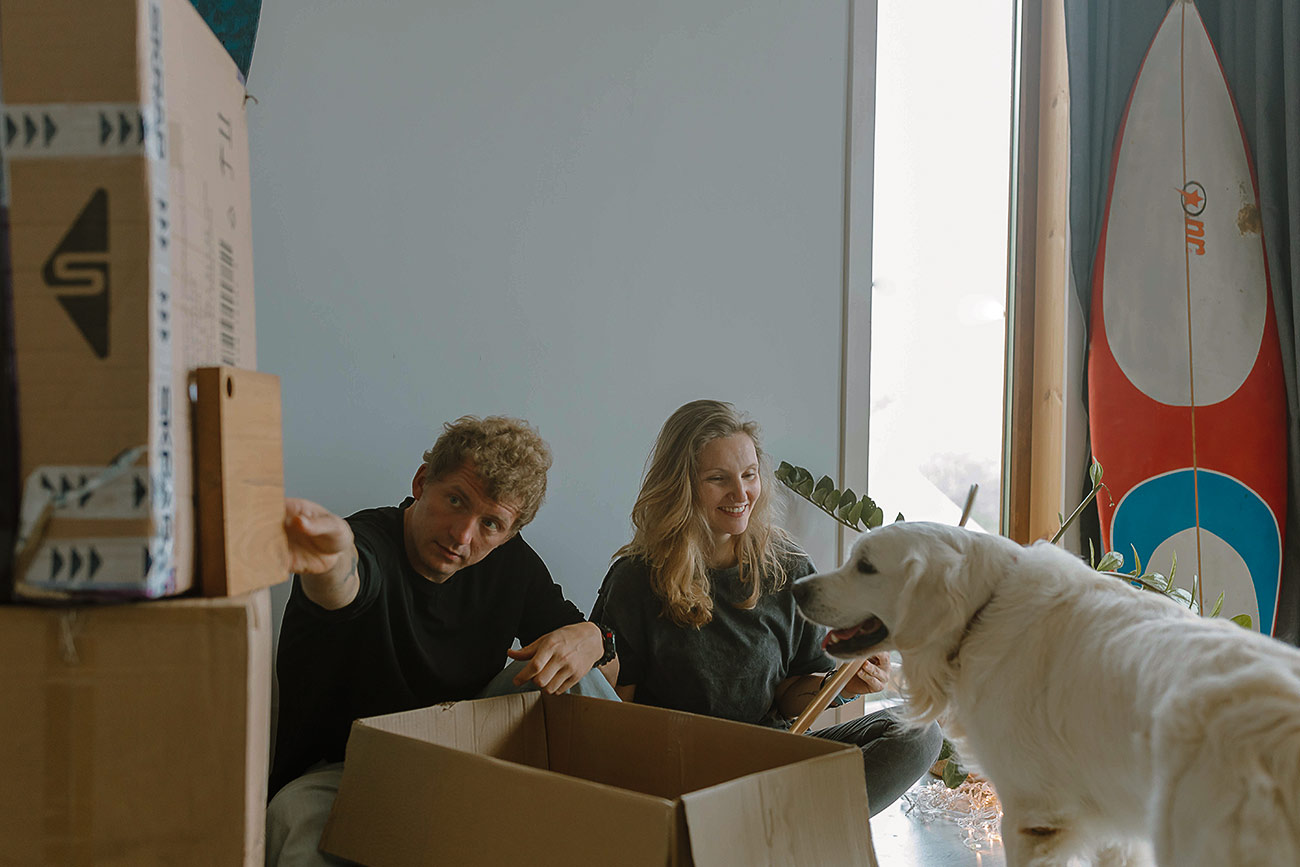 Couple with a dog preparing for moving in a new house